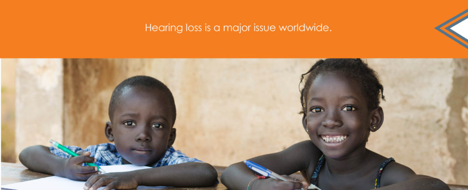 Two children smile while writing with pencils in notebooks. Text says, "Hearing loss is a major issue worldwide."