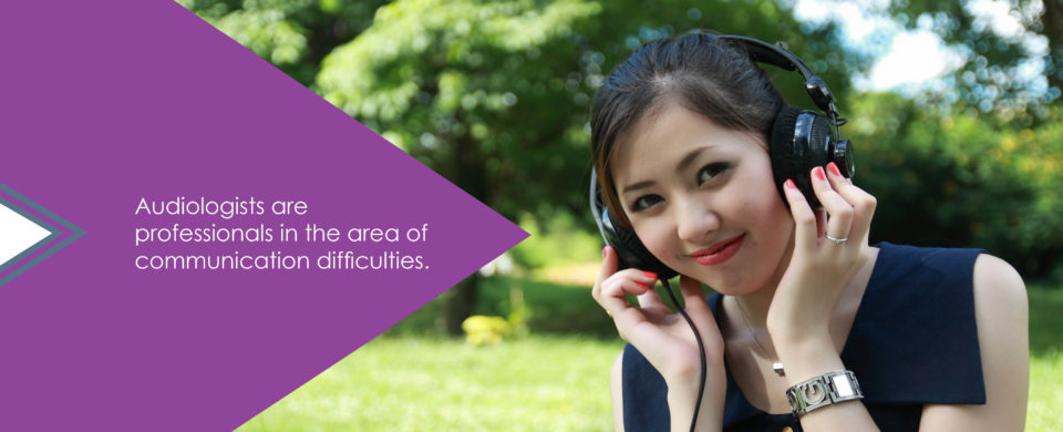 A young woman listens to headphones and smiles. Text says, "Audiologists are professionals in the area of communication difficulties."